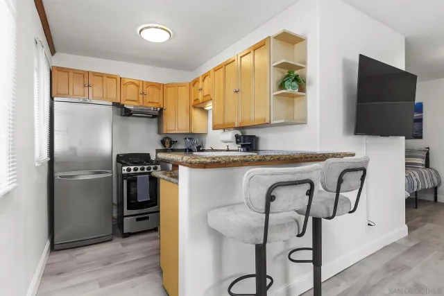 a kitchen with stainless steel appliances granite countertop a refrigerator and a stove top oven