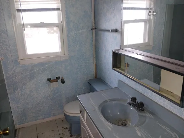 a bathroom with a sink a toilet and window