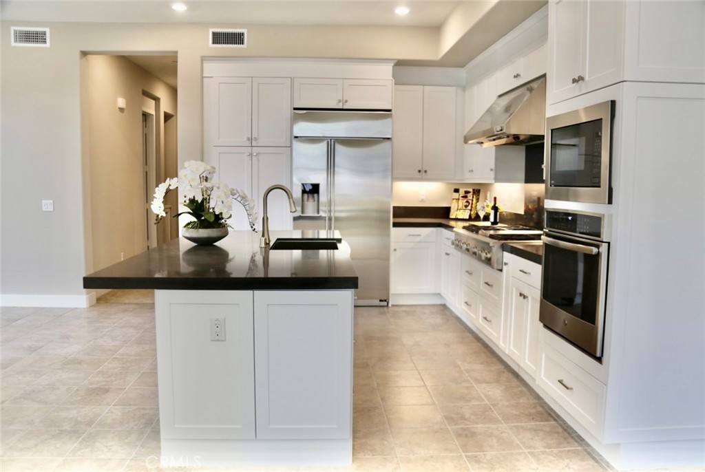 109 Pitch Irvine, CA 92618 - Photo 2 of 14 a kitchen with stainless steel appliances granite countertop white cabinets a sink a stove and a refrigerator