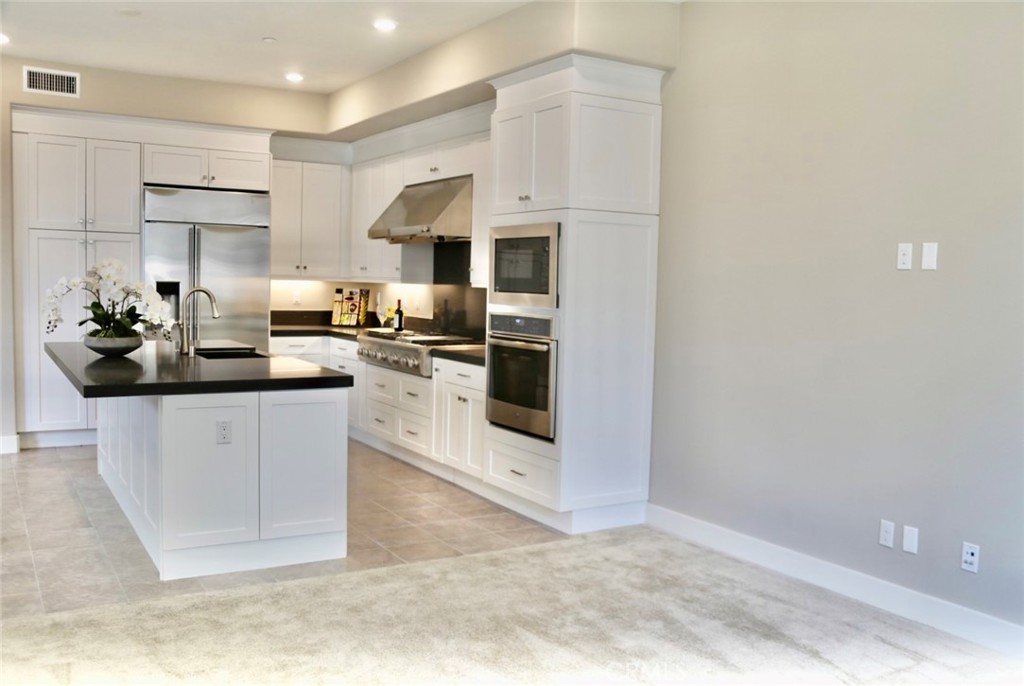 109 Pitch Irvine, CA 92618 - Photo 3 of 14 a kitchen with stainless steel appliances a sink a stove top oven a counter space and cabinets