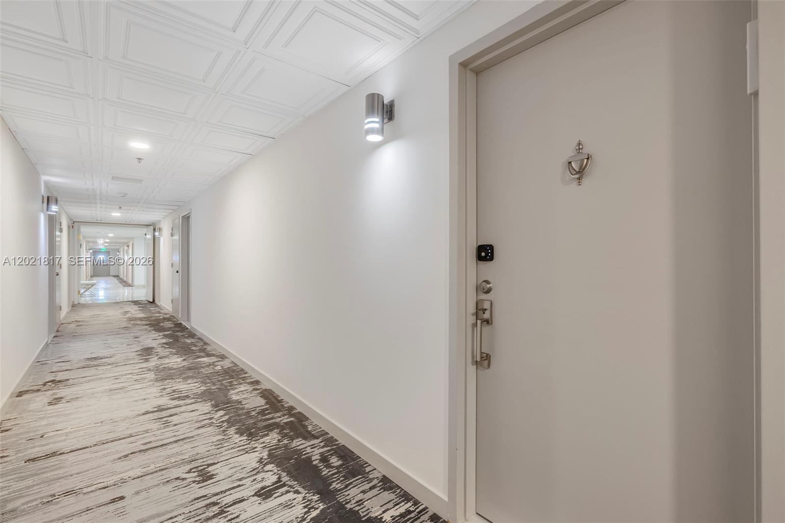 9511 Collins Avenue, Unit 1202 Surfside, FL 33154 - Photo 2 of 16 a view of a hallway with wooden floor and a bathroom