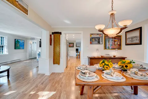 a dining room with furniture a rug and a chandelier