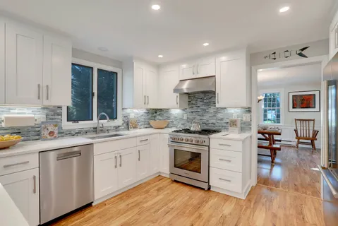a large kitchen with stainless steel appliances granite countertop a lot of counter space and wooden floors