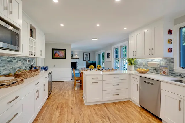 a kitchen that has a lot of cabinets and wooden floor
