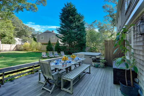 a view of a patio with table and chairs potted plants and floor to ceiling window with wooden floor