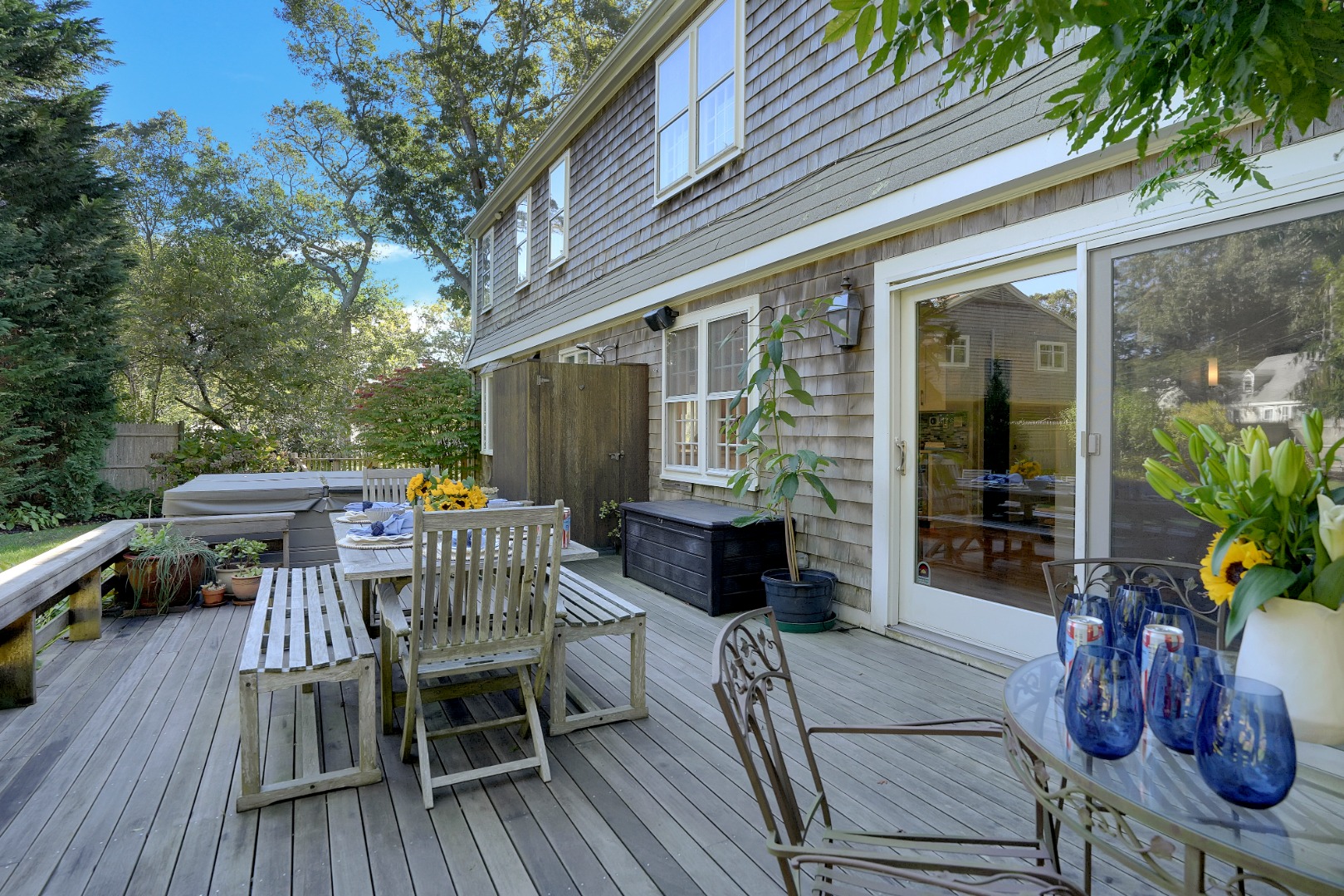 28 Pine Tree Lane Vineyard Haven, MA 02568 - Photo 27 of 61 a view of a patio with table and chairs potted plants and floor to ceiling window with wooden floor