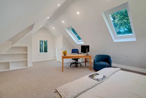 a bedroom with a bed and flat tv screen next to a window
