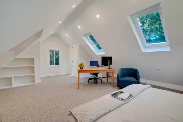 a bedroom with a bed and flat tv screen next to a window