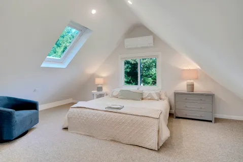 a bed sitting in a bedroom next to a window