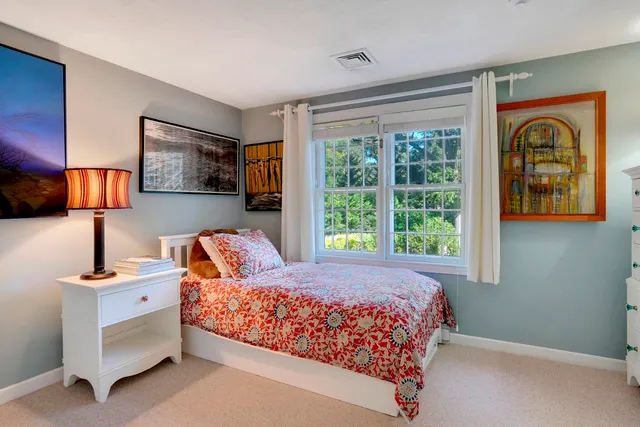 a bedroom with a large bed and a flat tv screen on dresser