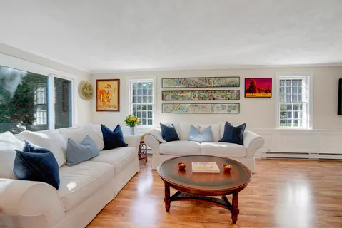 a living room with furniture and a wooden floor