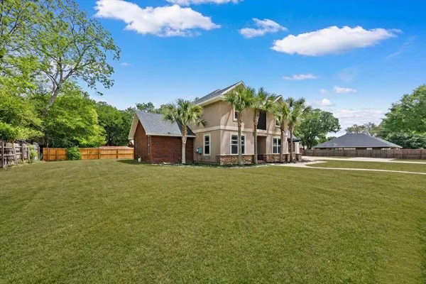 a view of a house with a patio and a yard