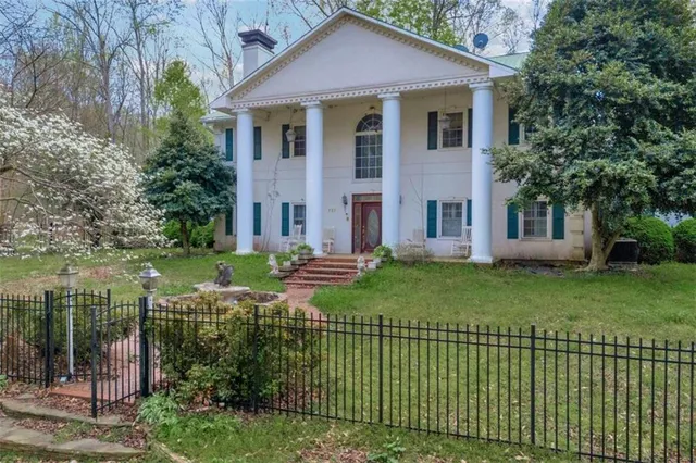 a front view of a house with a garden and plants