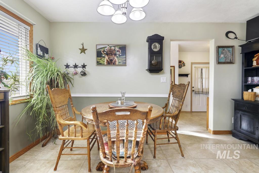 213 Sage Road West Jerome, ID 83338 - Photo 24 of 50 Dining space featuring a chandelier and light tile patterned flooring