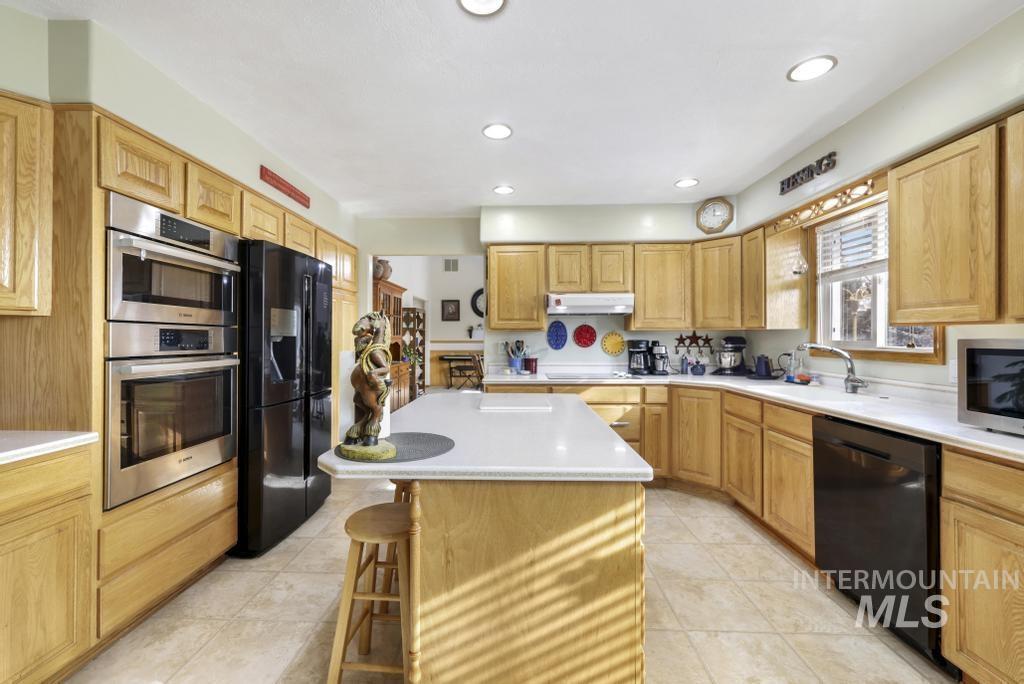 213 Sage Road West Jerome, ID 83338 - Photo 8 of 50 Kitchen with corian countertops, under cabinet range hood a kitchen island, nice appliances