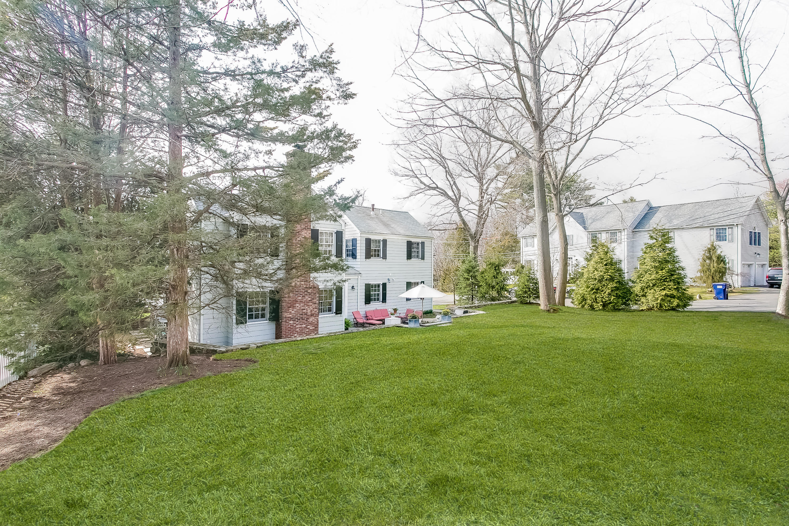 2 Miller Road Darien, CT 06820 - Photo 26 of 28 a view of a white house in front of a big yard with large trees