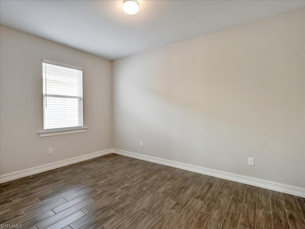 999 Enbrook Loop Naples, FL 34114 - Photo 13 of 50 wooden floor in an empty room with a window