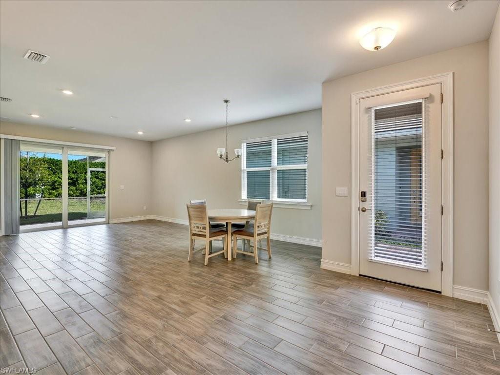 999 Enbrook Loop Naples, FL 34114 - Photo 2 of 50 an empty room with wooden floor and furniture
