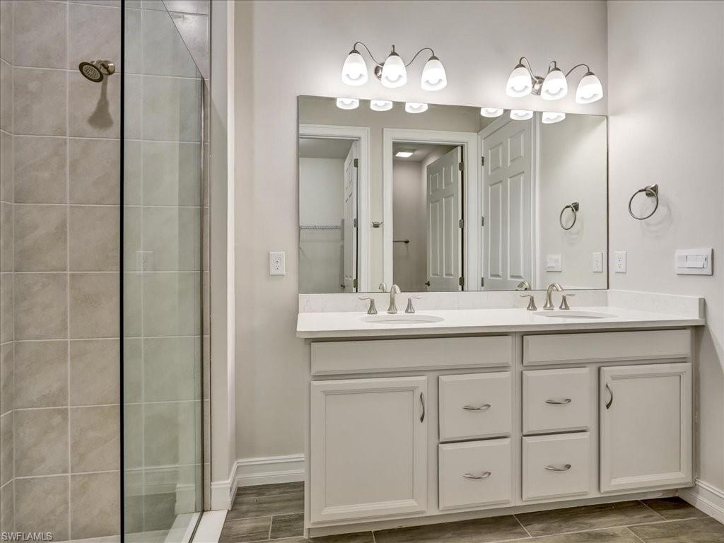 999 Enbrook Loop Naples, FL 34114 - Photo 29 of 50 a bathroom with a double vanity sink and a mirror