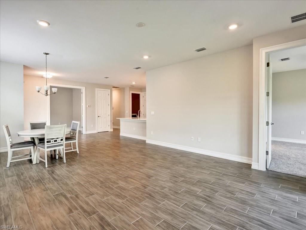 999 Enbrook Loop Naples, FL 34114 - Photo 3 of 50 a view of a big room with furniture and wooden floor