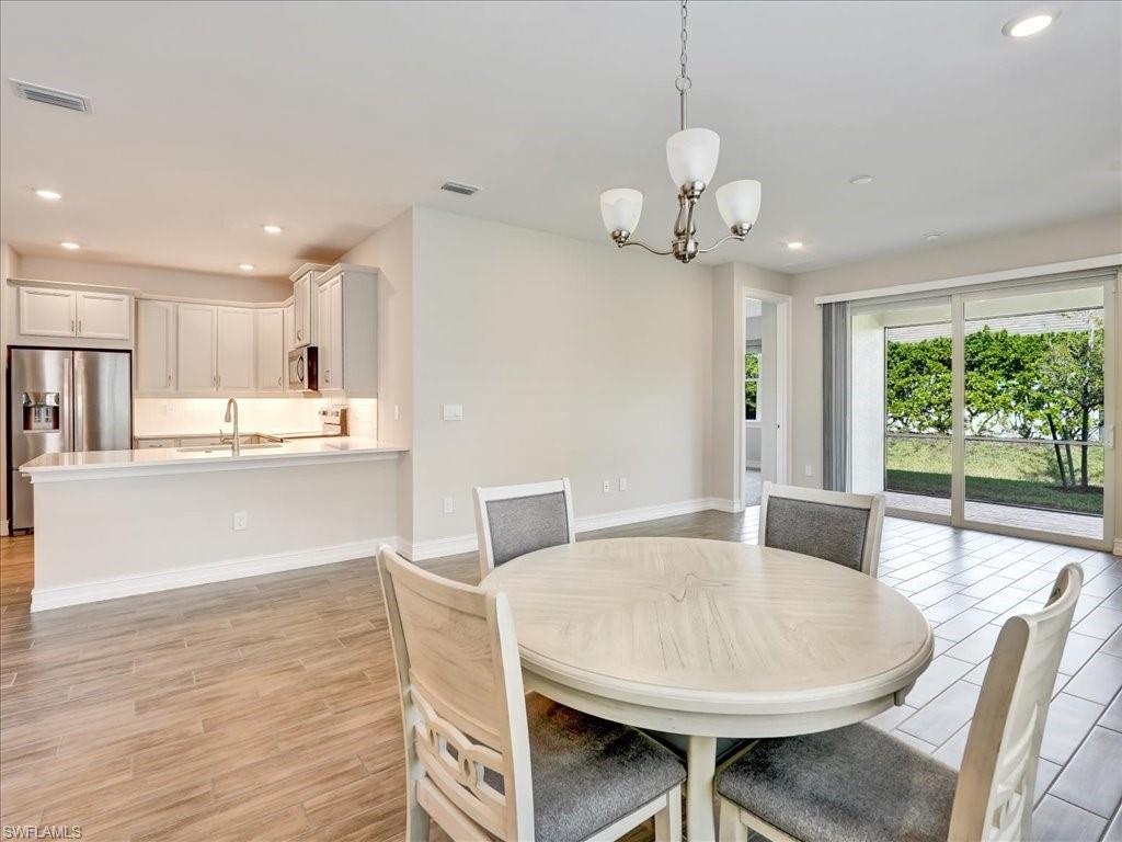 999 Enbrook Loop Naples, FL 34114 - Photo 4 of 50 a view of a dining room with furniture wooden floor and chandelier