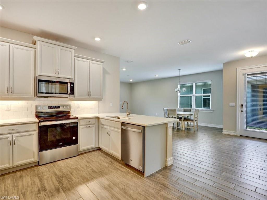 999 Enbrook Loop Naples, FL 34114 - Photo 9 of 50 a kitchen with a stove and a sink