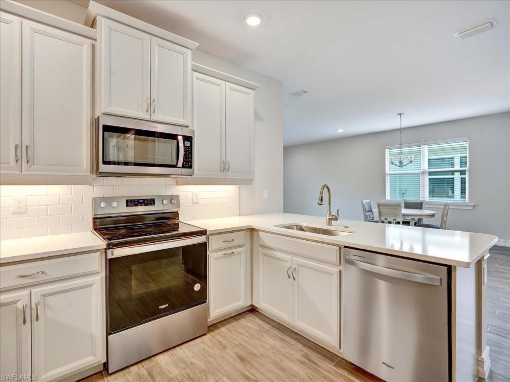 999 Enbrook Loop Naples, FL 34114 - Photo 10 of 50 a kitchen with cabinets stainless steel appliances a sink and a window