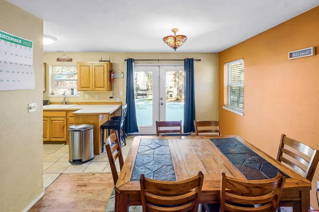 a dining room with stainless steel appliances furniture a window and kitchen view