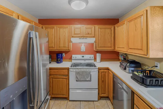 a kitchen with a stove top oven and refrigerator