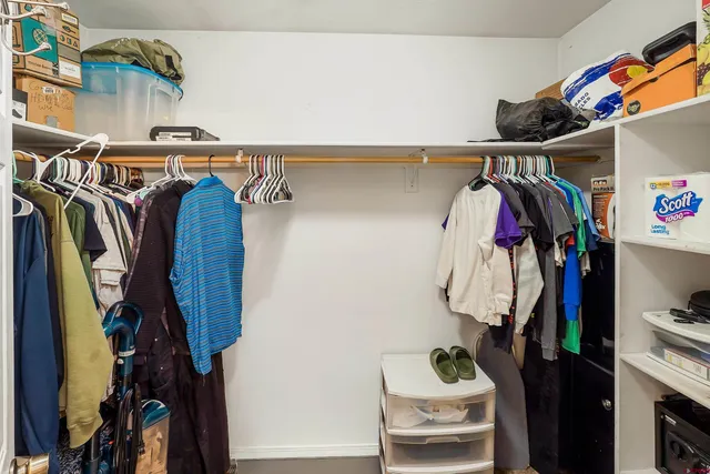 a view of walk in closet with clothes and shoes
