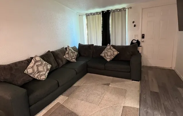 a living room with furniture and a wooden floor