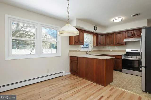 a kitchen with stainless steel appliances granite countertop a stove a sink dishwasher a refrigerator and a wooden cabinets