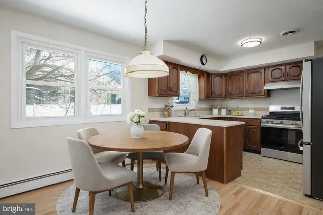 a kitchen with a dining table chairs and white cabinets
