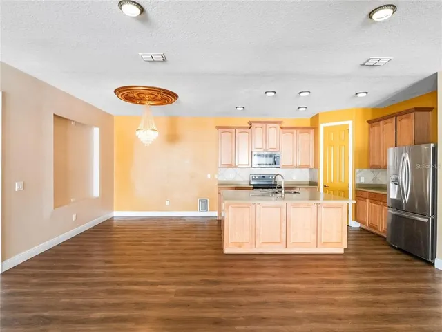 a kitchen with stainless steel appliances granite countertop a refrigerator and a stove top oven