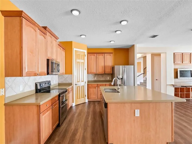 a kitchen with stainless steel appliances granite countertop sink stove top oven and large window