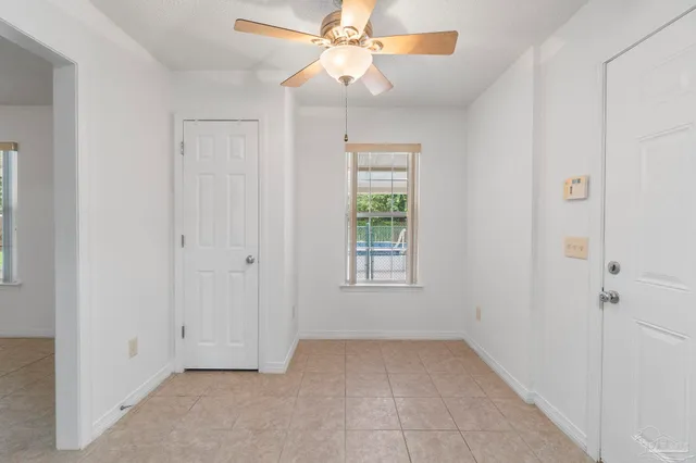 an empty room with fan and windows