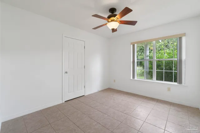 an empty room with a window and a fan
