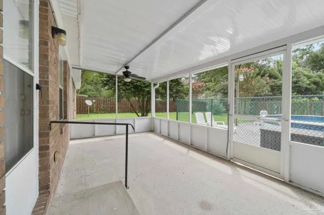 a view of an empty room with wooden floor and a large window