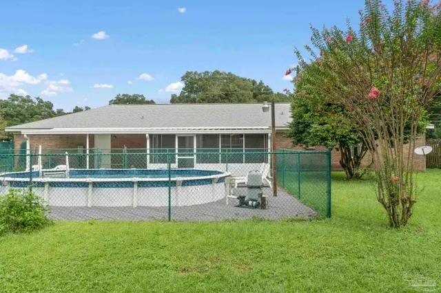 a view of a house with backyard and a tree
