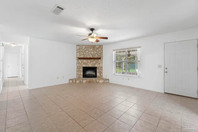 an empty room with windows and fireplace