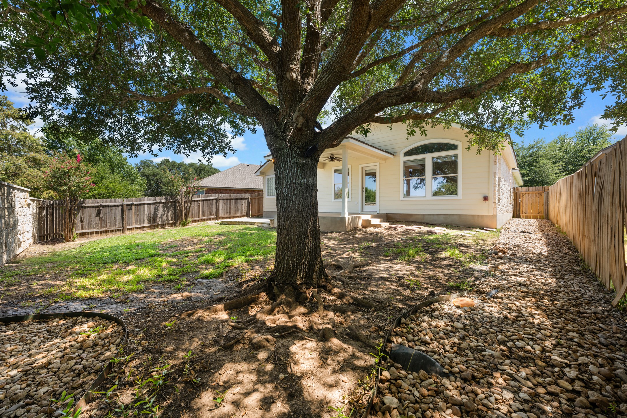 14316 Marathon Road Austin, TX 78717 - Photo 33 of 40 An expansive fenced backyard features a mature shade tree and a small covered back porch.