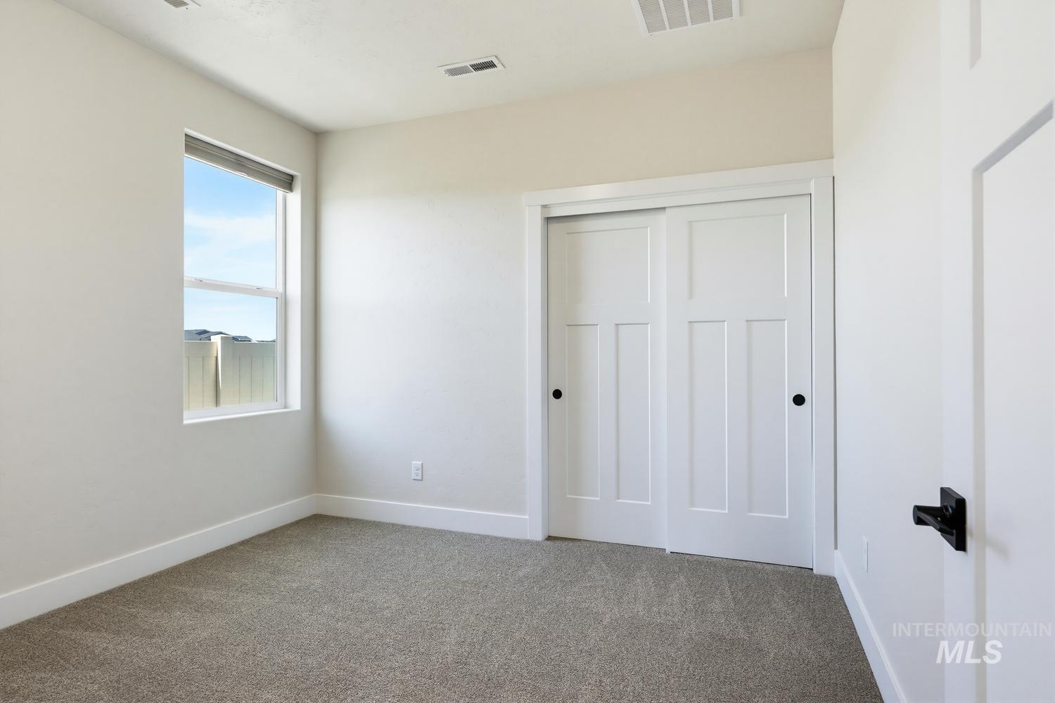 5990 West Ladle Rpds Street Meridian, ID 83646 - Photo 31 of 42 Neutral-toned carpeting, white walls, and a window with a roller shade