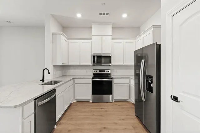 a kitchen with a sink stainless steel appliances and cabinets