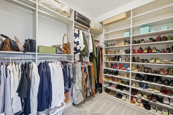 a view of walk in closet with clothes and shoes