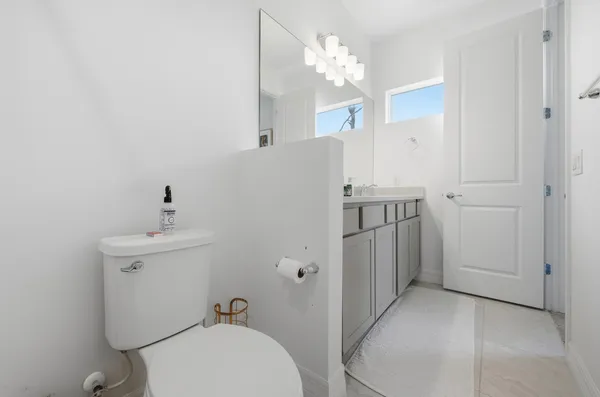 a bathroom with a toilet a sink and mirror