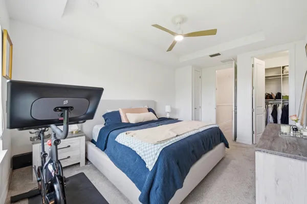 a bedroom with a bed and a mirror on the dresser