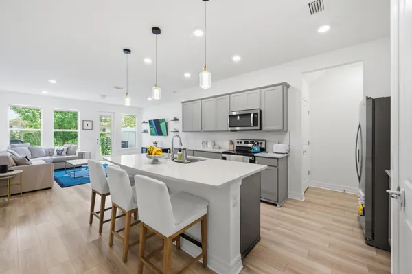 a kitchen with a sink a counter top space stainless steel appliances and wooden floor
