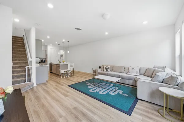 a living room with furniture and a wooden floor