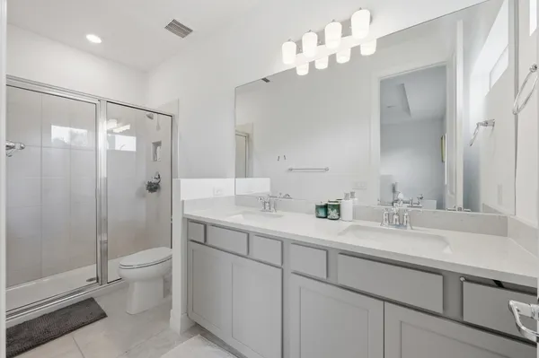 a bathroom with a double vanity sink mirror and toilet