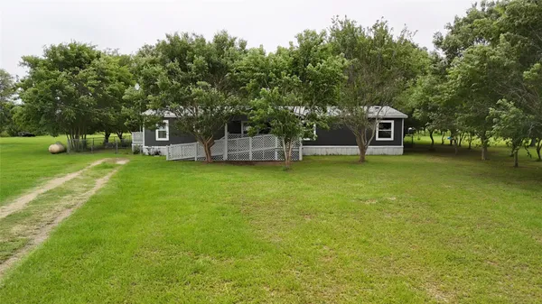 a view of a house with a garden and sitting area